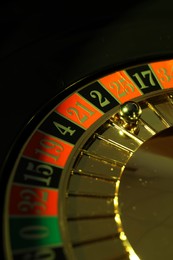 Roulette wheel with ball on black background, closeup. Casino game