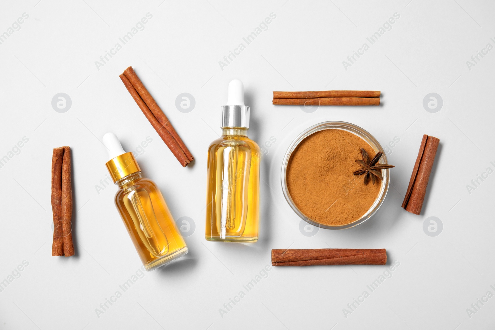 Photo of Flat lay composition with cinnamon essential oil on white background