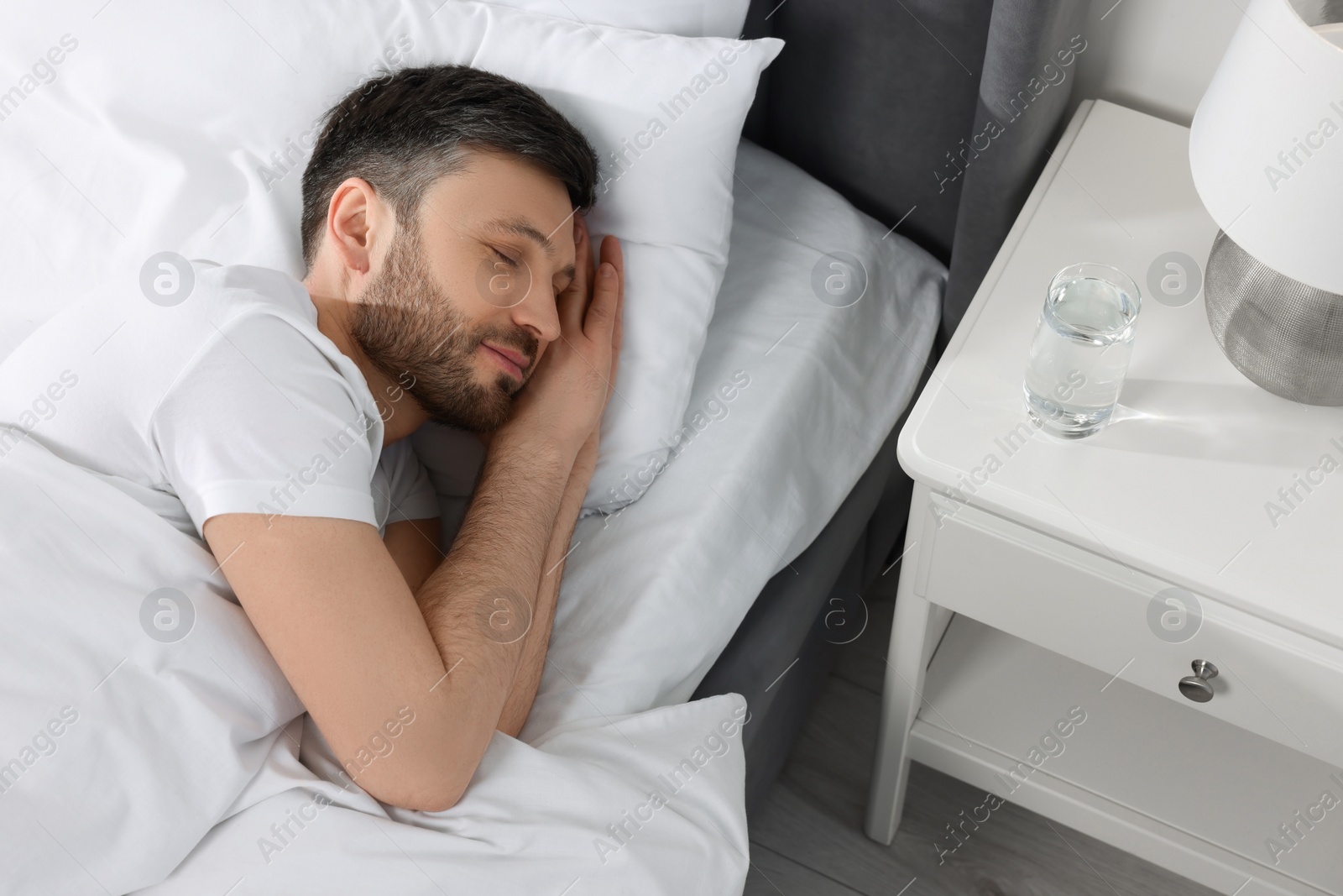 Photo of Handsome man sleeping in soft bed at home