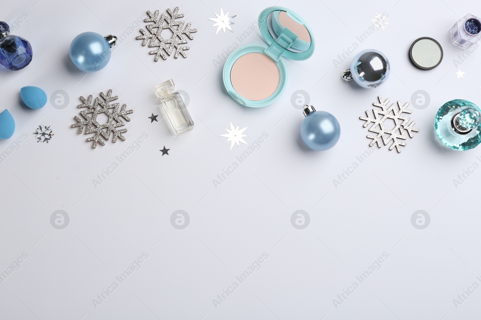 Photo of Flat lay composition with decorative cosmetic products on light background. Winter care. Space for text