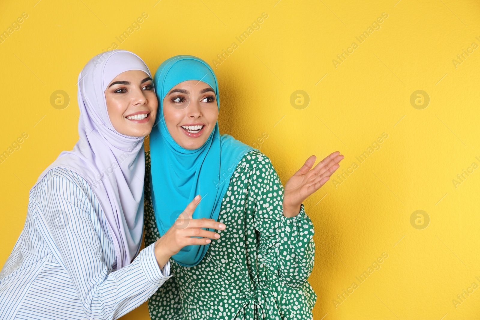 Photo of Portrait of young Muslim women in hijabs against color background