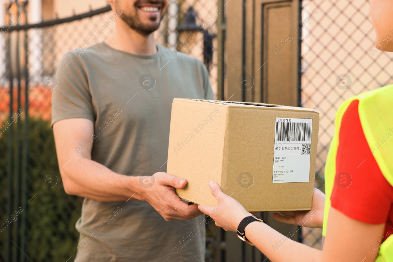 Photo of Man receiving parcel from courier outdoors, closeup