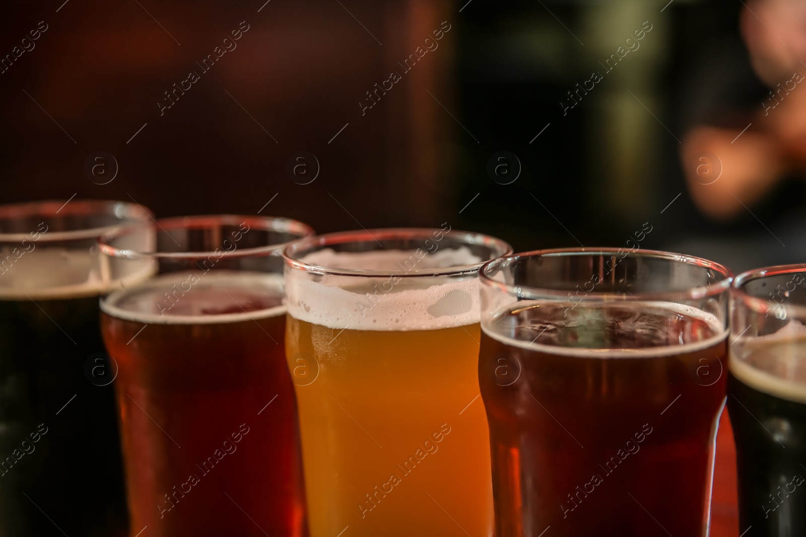 Photo of Glasses of different beer on dark background, closeup