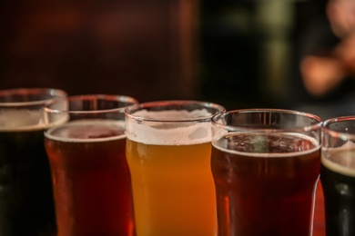 Glasses of different beer on dark background, closeup
