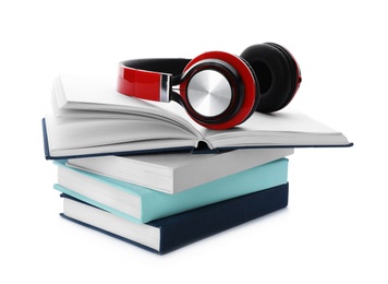 Photo of Modern headphones with hardcover books on white background