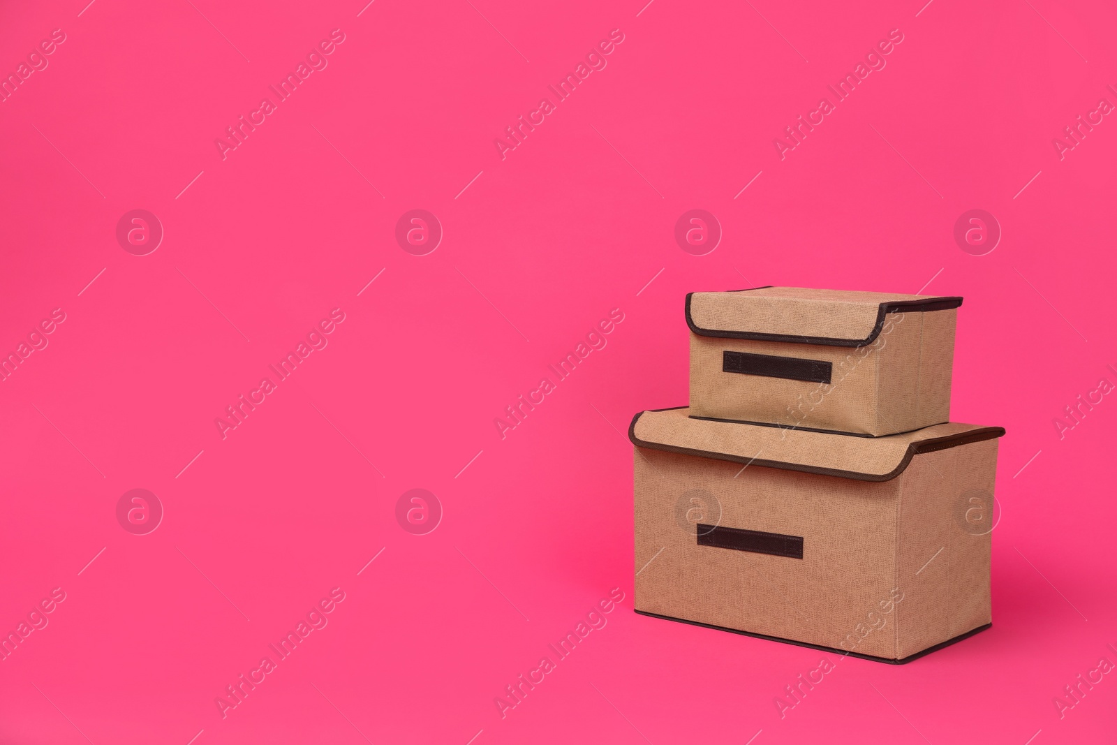 Photo of Two textile storage cases on pink background. Space for text