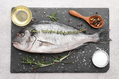 Raw dorado fish and ingredients on light grey table, top view