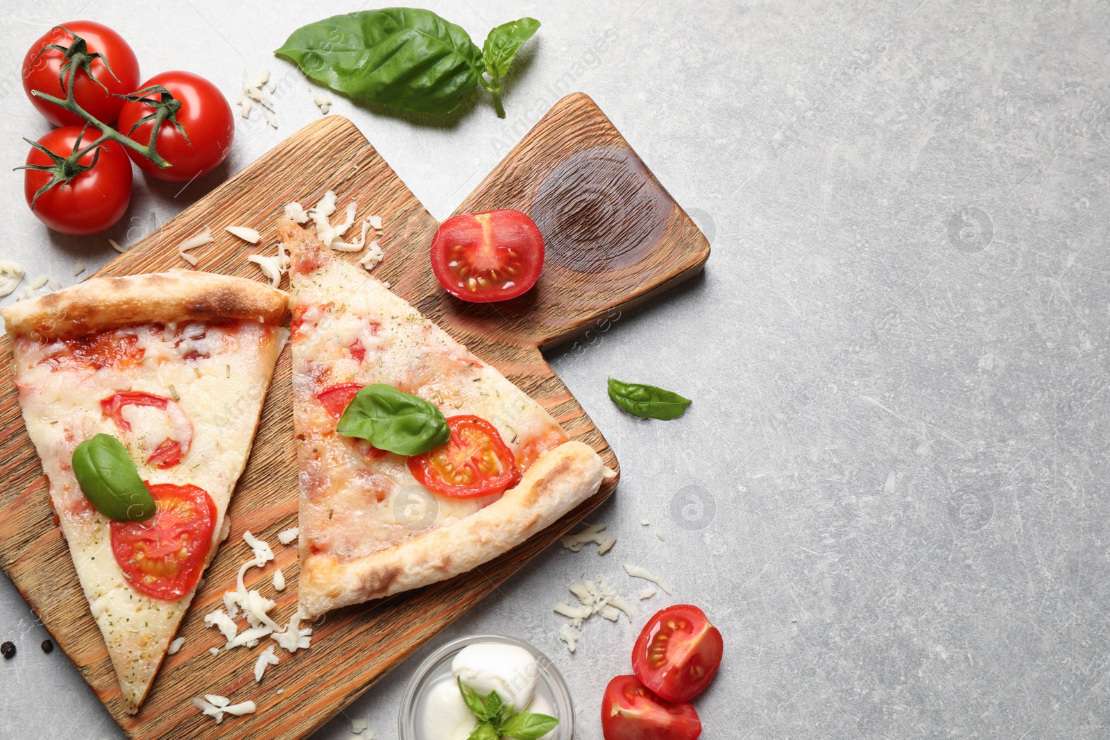 Photo of Slices of delicious pizza Margherita on light grey table, flat lay