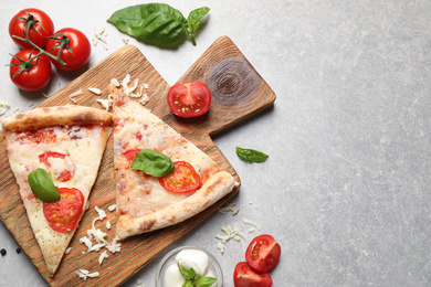 Photo of Slices of delicious pizza Margherita on light grey table, flat lay