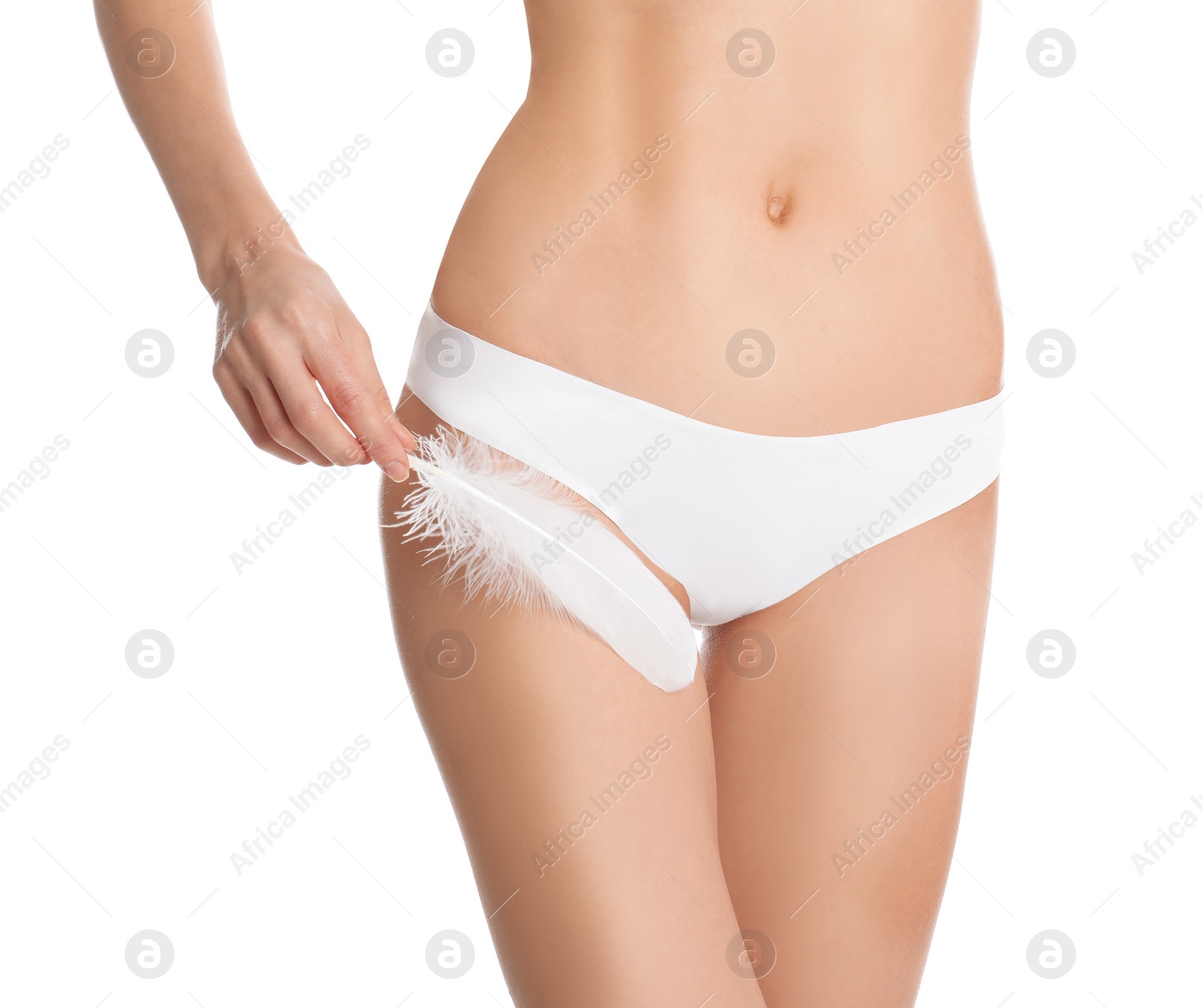 Photo of Woman with feather showing smooth skin after bikini epilation on white background, closeup. Body care concept