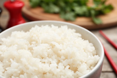 Photo of Bowl of boiled rice on table, closeup