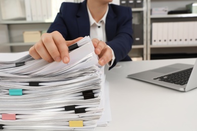 Photo of Woman working with documents at table in office, closeup. Space for text