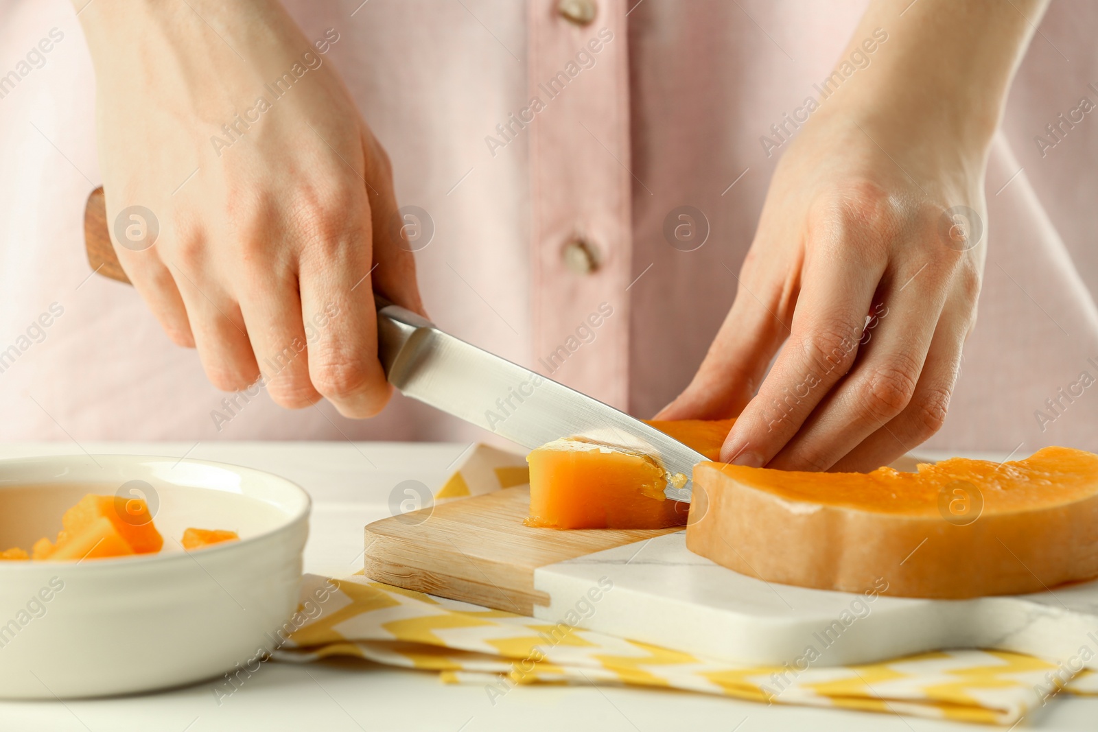 Photo of Woman cutting boiled pumpkin at table, closeup. Child's food