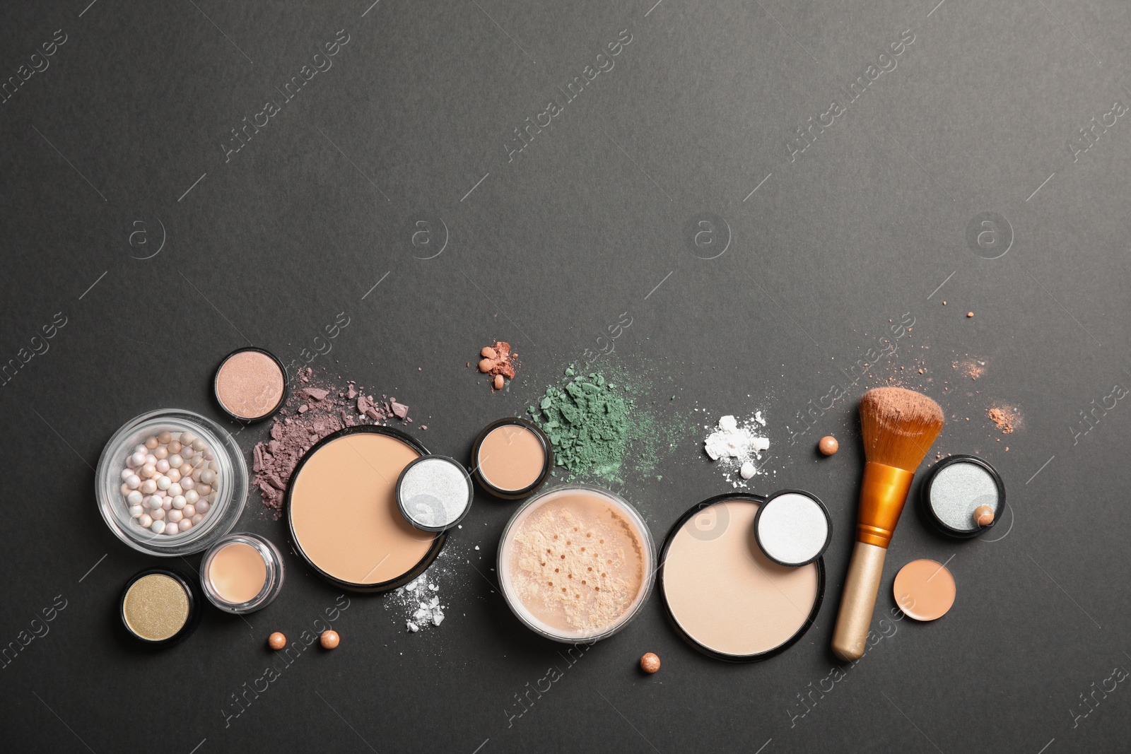 Photo of Flat lay composition with various makeup face powders on dark background. Space for text