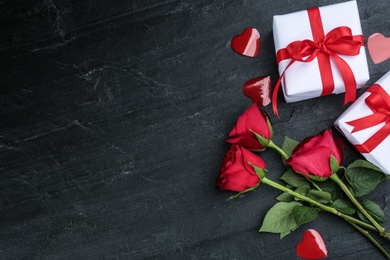 Photo of Gift boxes, roses and hearts on black background, flat lay with space for text. Valentine's Day celebration