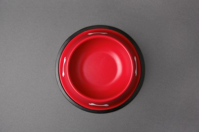 Photo of Empty red feeding bowl on dark grey background, top view