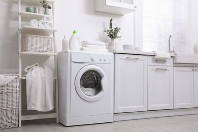 Kitchen interior with washing machine and stylish furniture