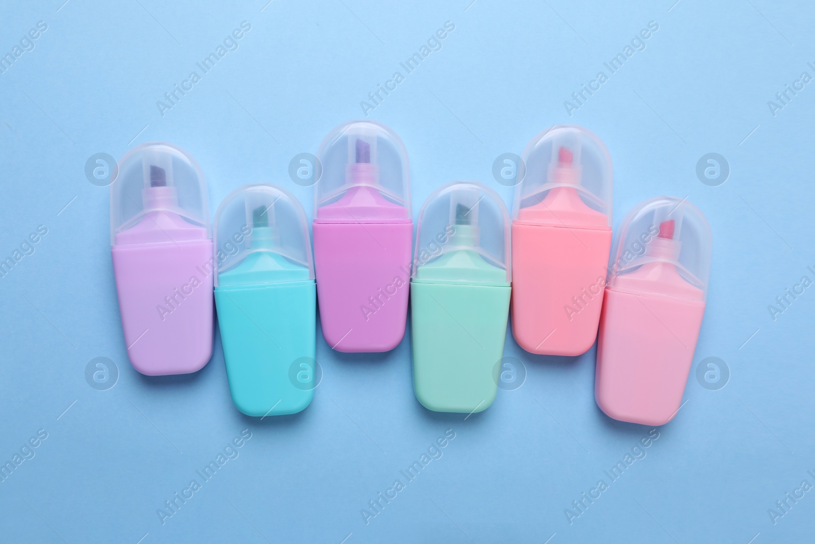 Photo of Many colorful markers on light blue background, flat lay