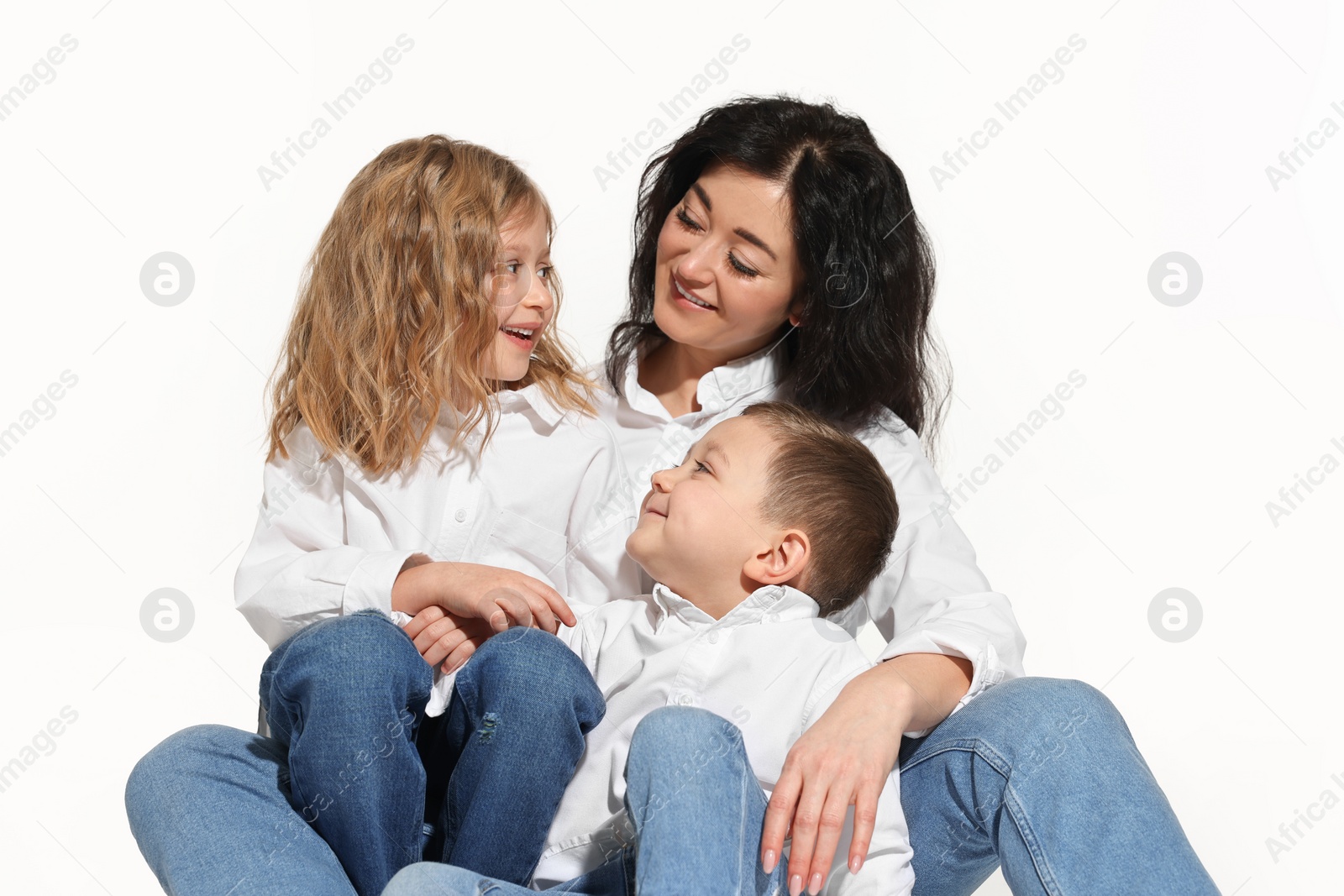 Photo of Little children with their mother sitting together on white background