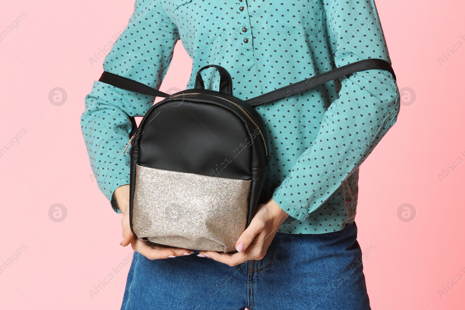 Photo of Fashionable woman with backpack on color background, closeup