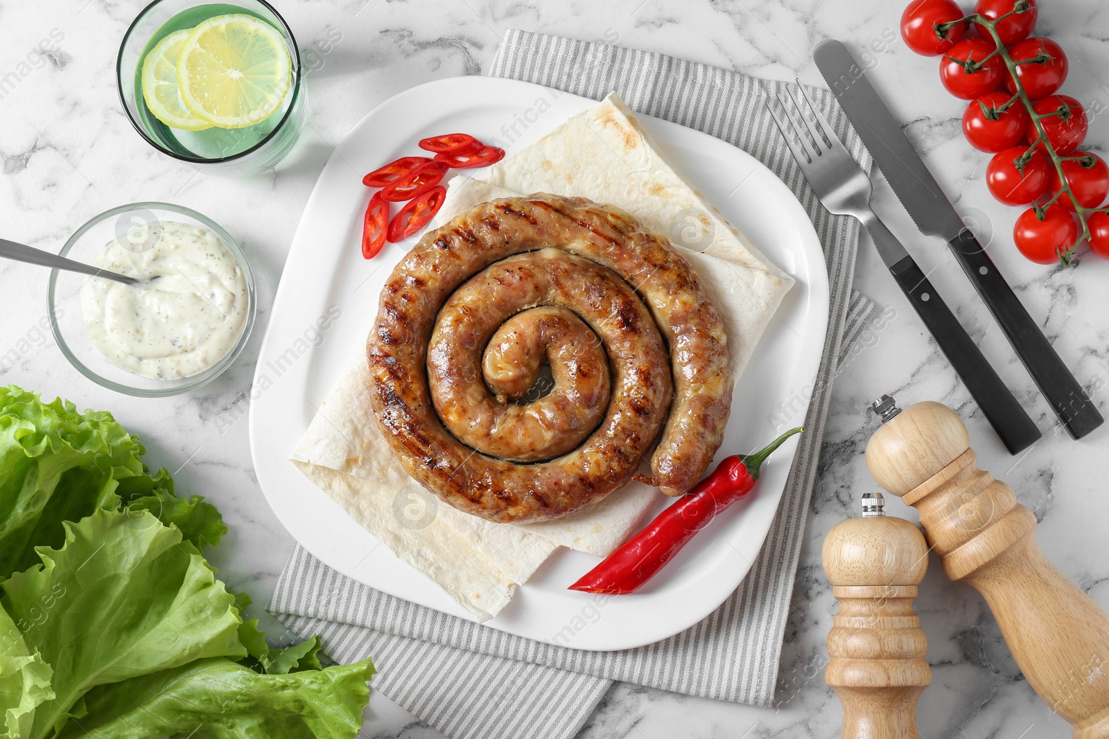 Photo of Tasty homemade sausage with chili pepper and lavash served on white marble table, flat lay