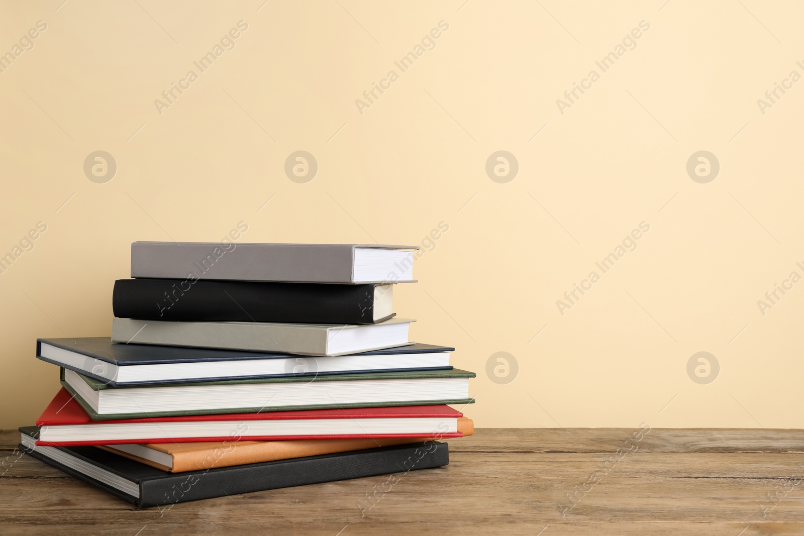 Photo of Stack of hardcover books on wooden table, space for text