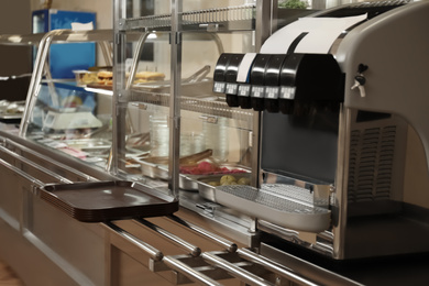 Photo of Serving line with tasty food and beverage dispenser in school canteen