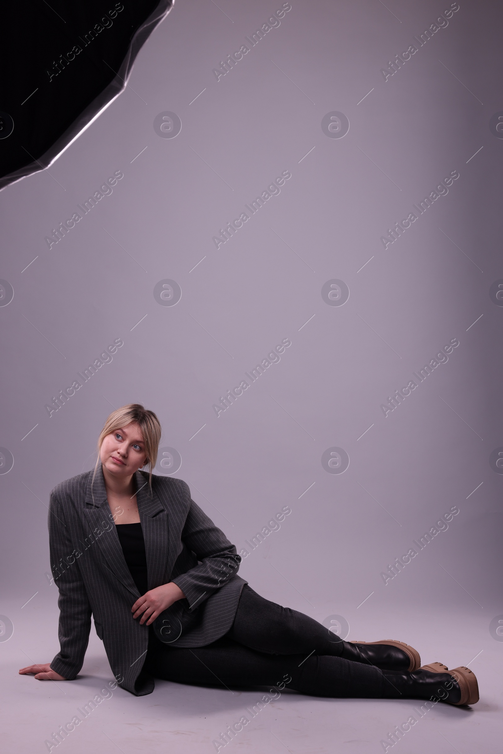 Photo of Beautiful young woman posing on grey background