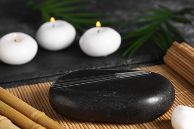 Photo of Stone with acupuncture needles on bamboo mat
