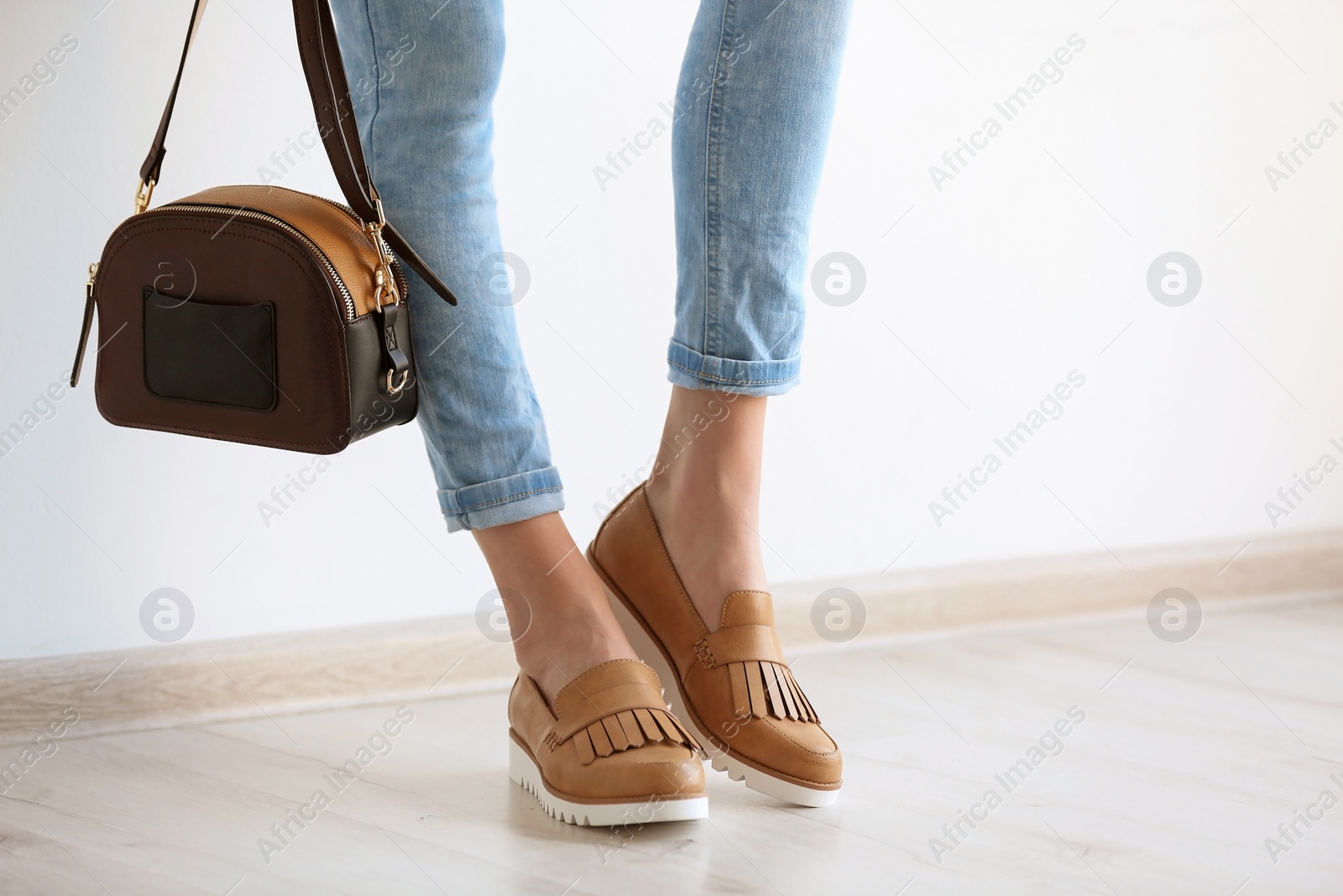 Photo of Young woman wearing elegant shoes indoors, closeup