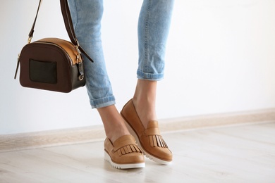 Young woman wearing elegant shoes indoors, closeup