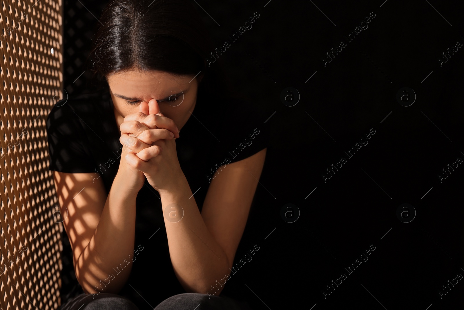 Photo of Upset woman listening to priest during confession near in booth, space for text