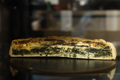 Delicious spinach quiche on counter in bakery shop, closeup. Space for text