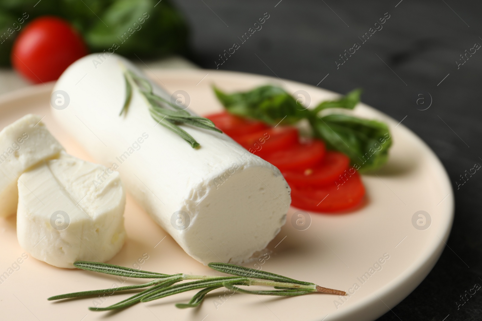 Photo of Delicious goat cheese with rosemary on plate, closeup