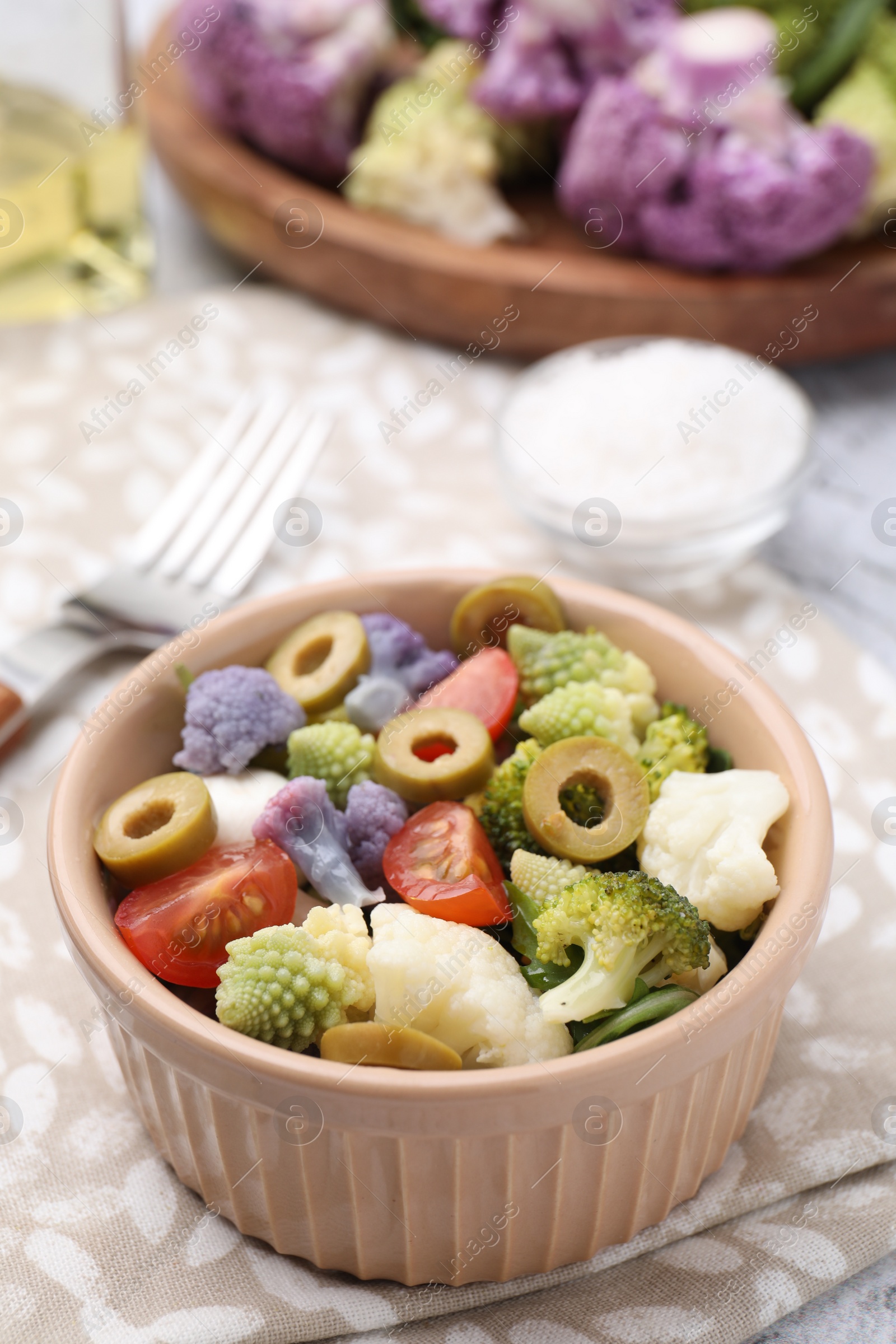 Photo of Delicious salad with cauliflower, tomato and olives on table