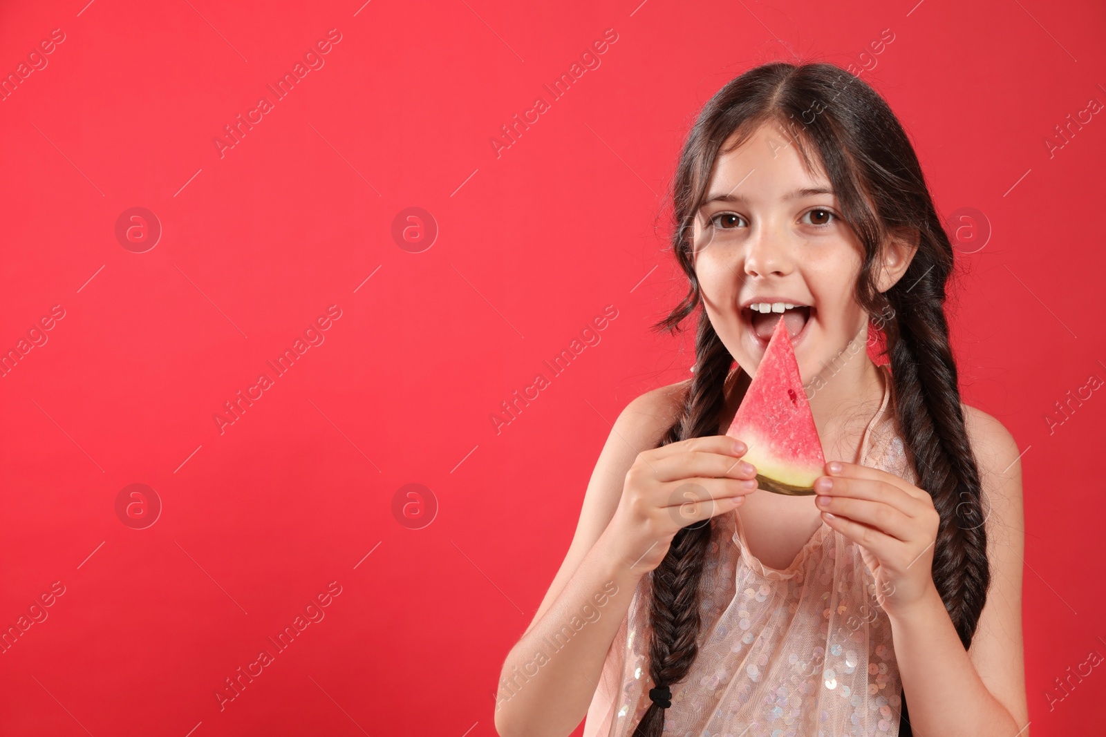 Photo of Cute little girl with watermelon on red background. Space for text