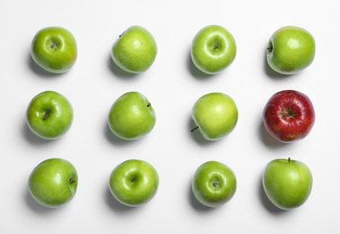 Photo of Red apple among green ones on white background, top view