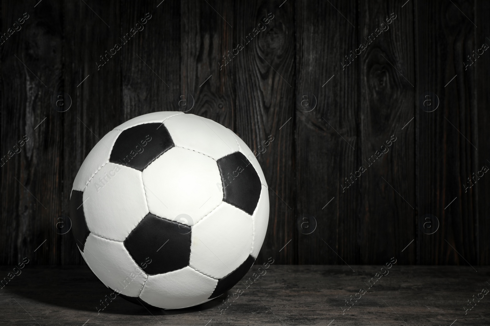 Photo of New soccer ball on table against wooden background. Football equipment