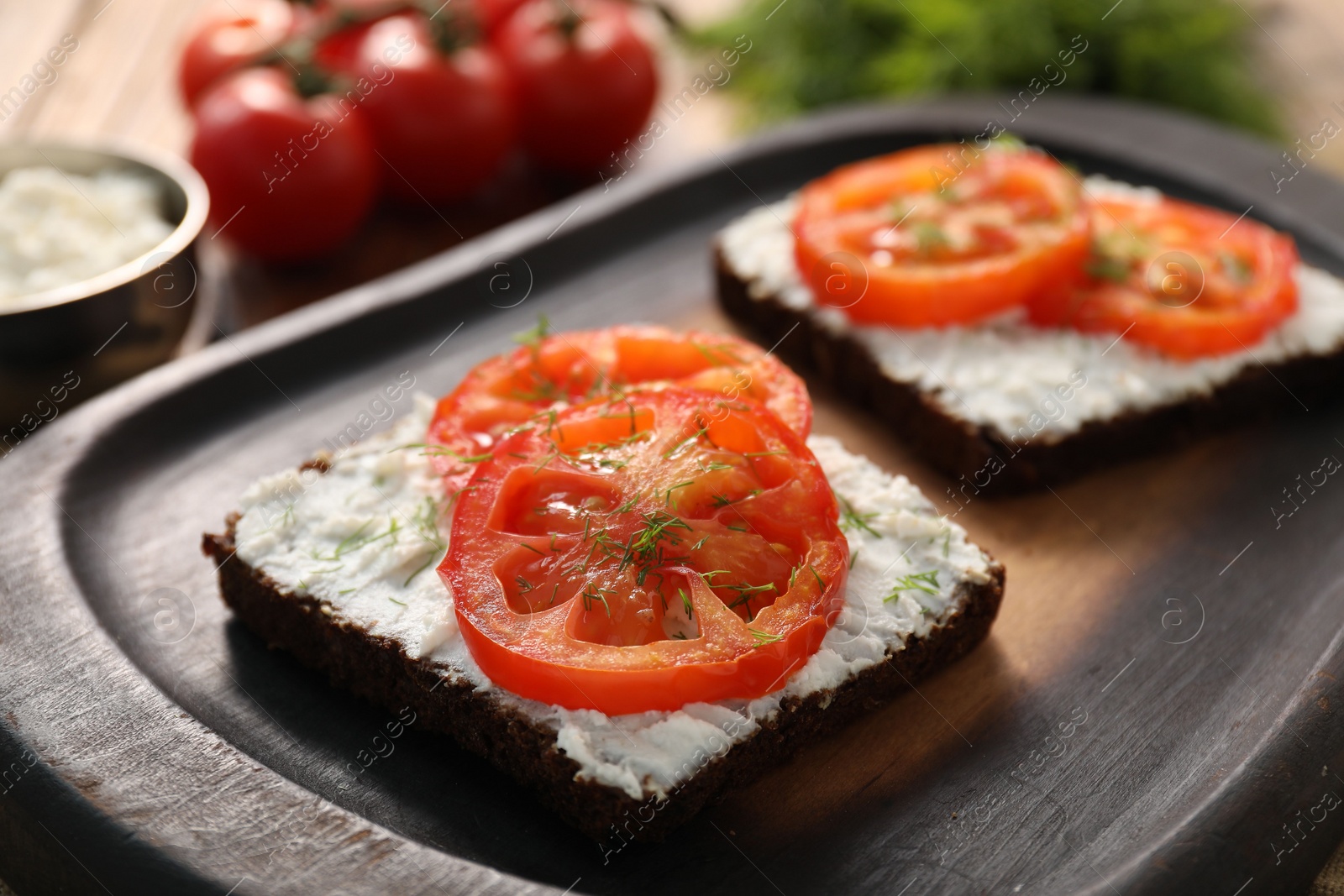 Photo of Delicious ricotta bruschettas with sliced tomatoes and dill on wooden table, closeup