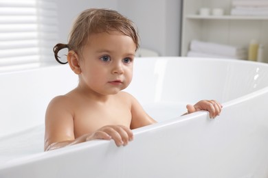 Photo of Cute little girl taking bath at home