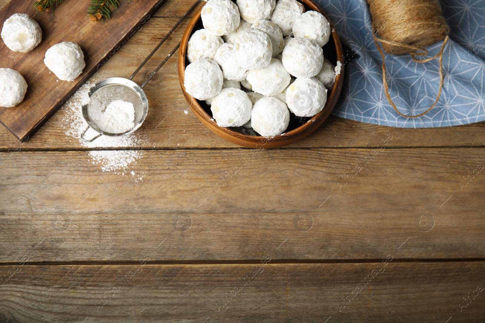 Photo of Flat lay composition with Christmas snowball cookies on wooden table, space for text