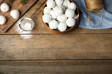 Photo of Flat lay composition with Christmas snowball cookies on wooden table, space for text