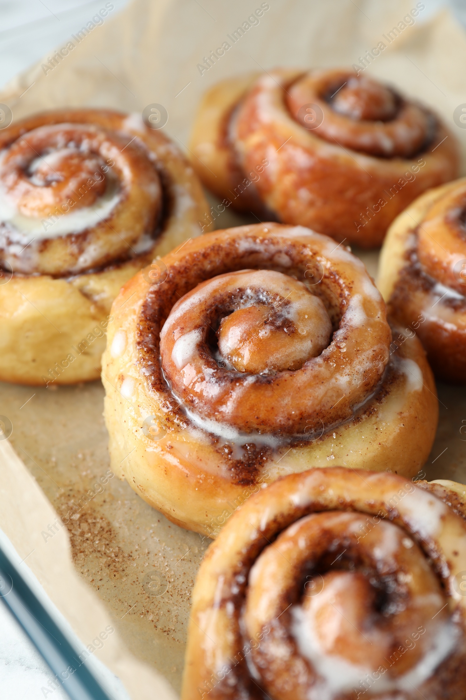 Photo of Baking dish with tasty cinnamon rolls on white table, closeup