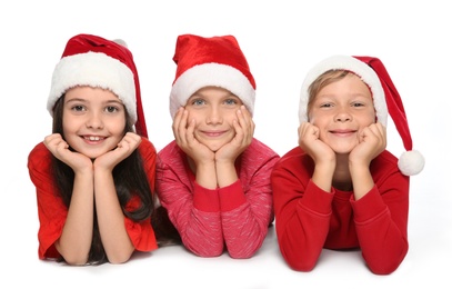 Photo of Cute little children in Santa hats on white background. Christmas celebration