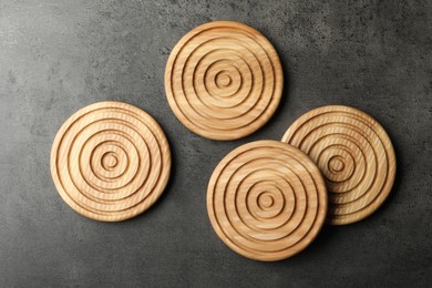 Stylish wooden cup coasters on dark grey table, flat lay