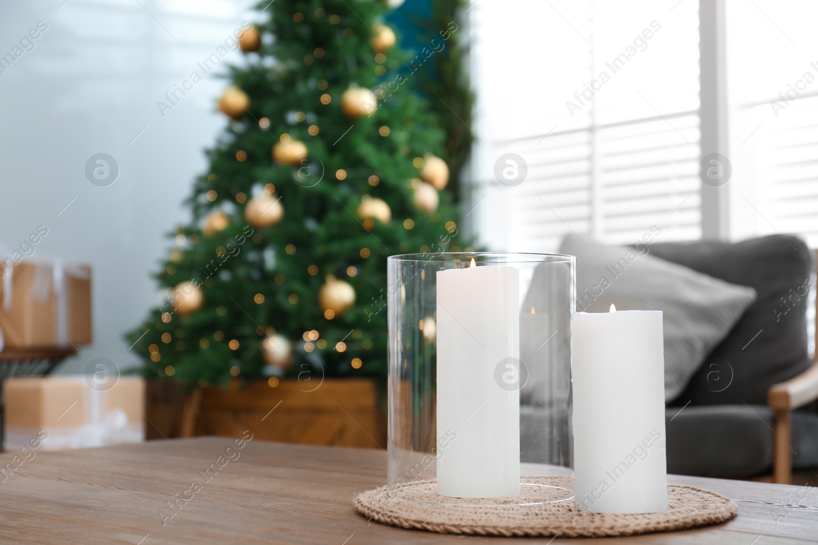 Photo of Beautiful decorated Christmas tree in living room, focus on burning candles