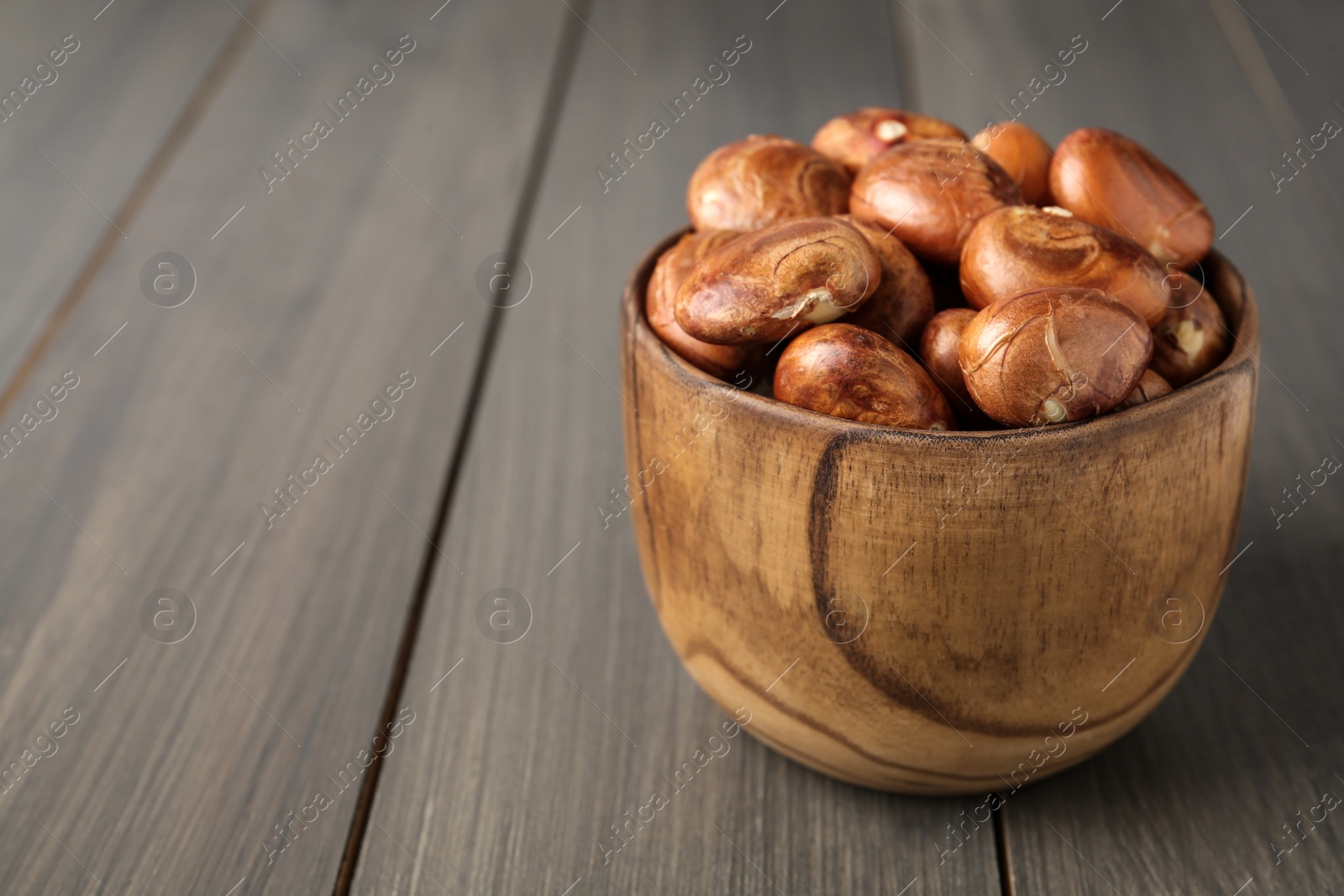 Photo of Bowl of jackfruit seeds on wooden table. Space for text