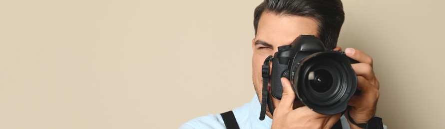 Image of Professional photographer with camera beige background, space for text. Banner design