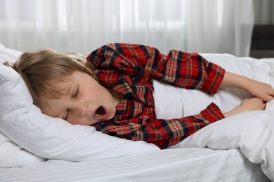 Photo of Little boy snoring while sleeping in bed at home