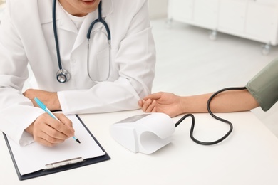 Photo of Doctor checking patient's blood pressure in hospital
